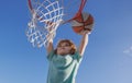 Basketball Slam Dunks of sporty kids basketball player. Close up image of basketball excited kid player dunking the ball