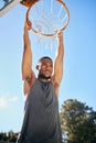 Basketball, sports and black man hanging on hoop at a game during summer. Energy, action and African athlete thinking at Royalty Free Stock Photo