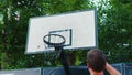 Basketballer jumps and throws ball into rim