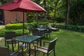 The basketry chair, table and red umbrella set in the garden, in the relax area Royalty Free Stock Photo