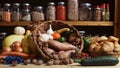 Baskets of Fresh Vegetables and Bread in Rustic Kitchen With Jars of Dried Food in Background Royalty Free Stock Photo