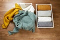 Baskets with neat piles of clothes and a scattered pile of knitted things.