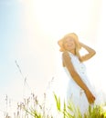 Basking in natures tranquility. A beautiful young blonde woman standing in a meadow wearing a sunhat on a warm summers Royalty Free Stock Photo