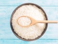 Basmati rice in ceramic bowl and wooden spoon on blue Royalty Free Stock Photo