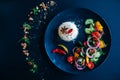 Basmati rice, salad, chili pepper. Dark background, black plate, top view