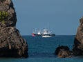 Two Basque fishing boats crossing the rocks of Laga.