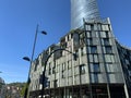 Basque glass industry tower in bilbao`s tree-lined park with modern building Royalty Free Stock Photo