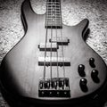 Bass electric guitar with four strings in black and white. Popular rock musical instrument. Top view of bass guitar, focus on
