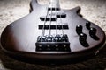 Bass electric guitar with four strings closeup. Detail of popular rock musical instrument. Close view of bass, focus on bridge Royalty Free Stock Photo