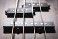 Bass electric guitar with four strings closeup. Detail of popular rock musical instrument. Close view of element of wooden