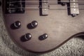 Bass electric guitar with four strings closeup. Detail of popular rock musical instrument. Close view of elements of wooden Royalty Free Stock Photo