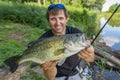 Bass fishing. Fisherman holding largemouth perch fish Royalty Free Stock Photo