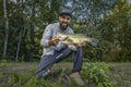 Bass fishing. Happy fisherman with big bass fish. Largemouth perch at pond Royalty Free Stock Photo