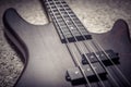 Bass guitar with four strings closeup. Detail of popular rock musical instrument. Close view of brown electric bass, selective Royalty Free Stock Photo