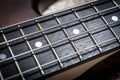 Bass guitar with four strings closeup. Macro photo of textured neck and frets of bass guitar Royalty Free Stock Photo