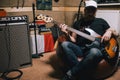 Bass guitarist with guitar in garage studio