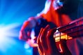 Bassist's hands playing melodic chords of new track in action with colorful concert light flare in background Royalty Free Stock Photo