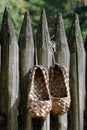 Bast shoes hanging on old wooden fence Royalty Free Stock Photo