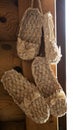 Bast shoes woven from the bark hang. Handmade, old shoes, traditional. Close-up Royalty Free Stock Photo