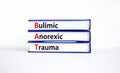 BAT bulimic anorexic trauma symbol. Concept words BAT bulimic anorexic trauma on books on a beautiful white table, white Royalty Free Stock Photo