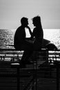 Bat-Yam, Israel - August 20, 2023 : The silhouette of a young couple sitting near the sea beach on sunset Royalty Free Stock Photo