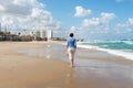 Bat Yam, Israel - 14 July, 2014. Slim old lady walking on the sandy beach