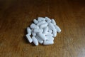 Batch of calcium tablets on wooden table