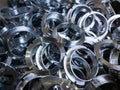 A batch of machined shiny metal parts with selective focus