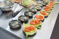 Batch of unfinished black burgers waiting for ground beef