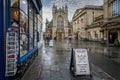 Bath Abbey on a wet day with cloudy blue sky in Bath, Somerset, UK