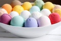 bath bombs in variety of colors in a white bowl