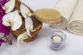Bath brush, rolled towels, tealight and orchids Royalty Free Stock Photo