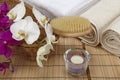 Bath brush, rolled towels, tealight and orchids Royalty Free Stock Photo