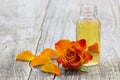 Bath oil and orange rose on wooden background Royalty Free Stock Photo