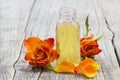 Bath oil and orange rose on wooden background Royalty Free Stock Photo