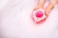 bath salt ball dissolves in the hands. Colored bath bomb Royalty Free Stock Photo