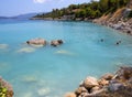 Bath in the sea with tourists and vacationers at the thermal healing hot springs of the Greek resort of Methana on the Peloponnese