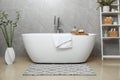 Soft bath towel and personal care products on tub tray in bathroom Royalty Free Stock Photo