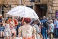 2019_07_25 Bath UK back of woman dressed in Regency Jane Austen period clothing with white ruffled parasol walking among crowd of