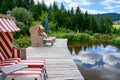 Bathing pond with gangplank, strandkorb, beach chair and blooming flowers and in small valley of Black Forest, Germany