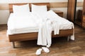 Bathrobe over bed in hotel room with white slippers Royalty Free Stock Photo
