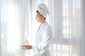 Bathrobe woman sunny window white curtains