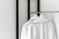 Bathrobes hanging on metal rack in white room Royalty Free Stock Photo