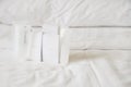 Bathroom accessories set in small package on white messy bed welcome for customer in hotel or resort Royalty Free Stock Photo