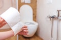 close-up in the hands of a woman toilet paper on the background of the bathroom Royalty Free Stock Photo