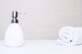 Bathroom background, toilet accessories for hand and body care, liquid soap dispenser and towels against light Royalty Free Stock Photo