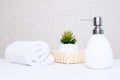 Bathroom background, toilet accessories for hand and body care, liquid soap dispenser and towels against light Royalty Free Stock Photo