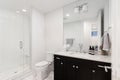 A bathroom with a black cabinet and white subway tile shower. Royalty Free Stock Photo