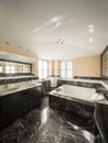 Bathroom with black marble tiles and empty big bathtub Royalty Free Stock Photo