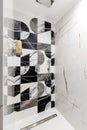 Bathroom with black white tiles, where a modern shower cabin without a pallet with chrome mixtures in modern style Royalty Free Stock Photo